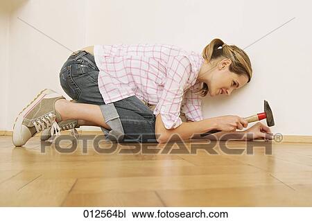 young woman trying to put a nail into a batten View Large Photo Image Stock Image - young woman trying to put a nail into a batten. Fotosearch