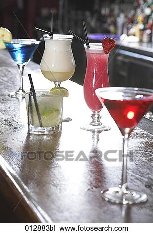 Stock Image - assortment of five cocktails on bar. Fotosearch