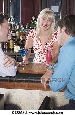 blond barmaid serving cocktails to guests View Large Photo Image Stock Image - blond barmaid serving cocktails to guests. Fotosearch