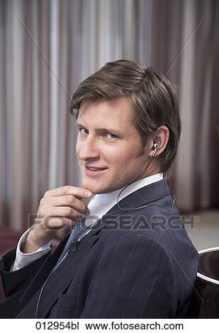 businessman with earphones showing mischievous expression View Large Photo Image Stock Image - businessman with earphones showing mischievous expression. Fotosearch