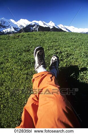 Stock Image - close-up of legs in front of mountain landscape. Fotosearch