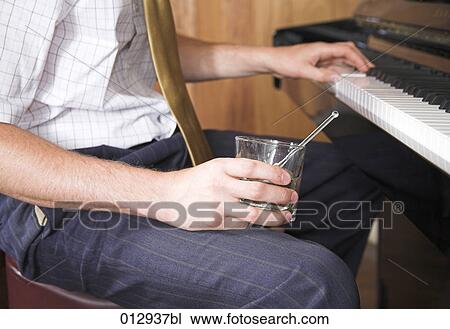 close-up of man holding glass while playing piano View Large Photo Image Stock Image - close-up of man holding glass while playing piano. Fotosearch
