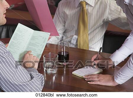 close-up of waitress standing at table writing down order in restaurant View Large Photo Image Stock Image - close-up of waitress standing at table writing down order in restaurant. Fotosearch