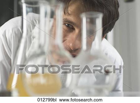 close-up portrait of chemist looking through flasks View Large Photo Image Stock Image - close-up portrait of chemist looking through flasks. Fotosearch