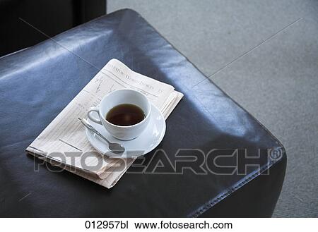 Stock Image - high angle view of coffee cup on business paper. Fotosearch