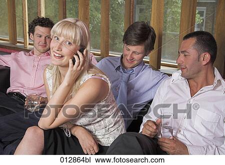 male friends throwing indecent looks at young woman talking on mobile View Large Photo Image Stock Image - male friends throwing indecent looks at young woman talking on mobile. Fotosearch