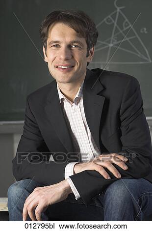 portrait of male teacher sitting in front of blackboard View Large Photo Image Stock Image - portrait of male teacher sitting in front of blackboard. Fotosearch
