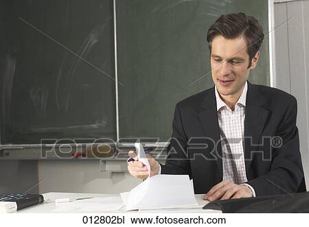 portrait of teacher checking documents in classroom View Large Photo Image Stock Image - portrait of teacher checking documents in classroom. Fotosearch