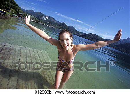 portrait of young woman standing in lake in Alpine landscape View Large Photo Image Stock Image - portrait of young woman standing in lake in Alpine landscape. Fotosearch