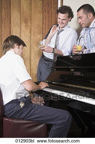 Stock Image - three businessmen enjoying some music after hours. Fotosearch