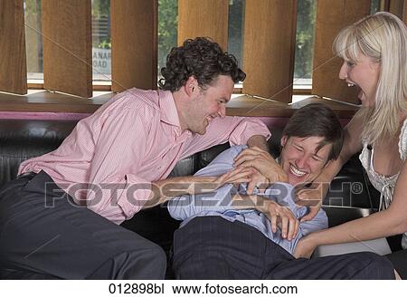 Stock Image - three fans goofing around in bar. Fotosearch