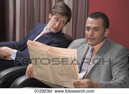 Stock Image - two businessman sitting together reading newspapers. Fotosearch