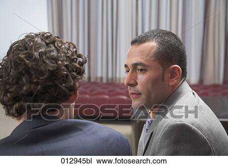 Stock Image - two businessmen having a conversation. Fotosearch