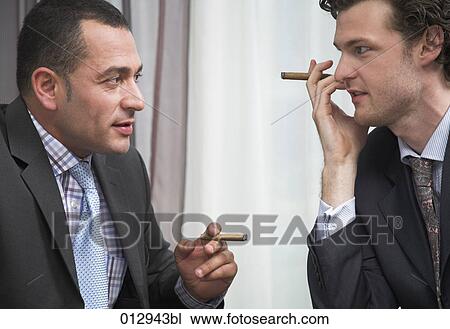 two businessmen with small cigars talking to each other View Large Photo Image Stock Image - two businessmen with small cigars talking to each other. Fotosearch