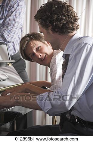 Stock Image - two friends playing piano together. Fotosearch