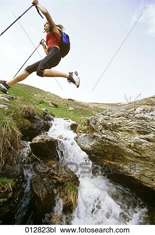 woman jumping over brook on nordic walking tour View Large Photo Image Stock Image - woman jumping over brook on nordic walking tour. Fotosearch