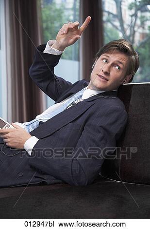 young businessman with ipod raising finger to order something at bar View Large Photo Image Stock Image - young businessman with ipod raising finger to order something at bar. Fotosearch