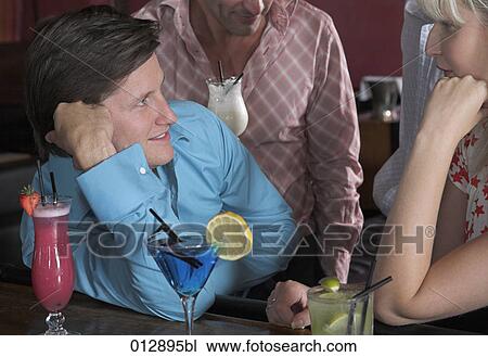 Stock Image - young couple flirting at bar. Fotosearch