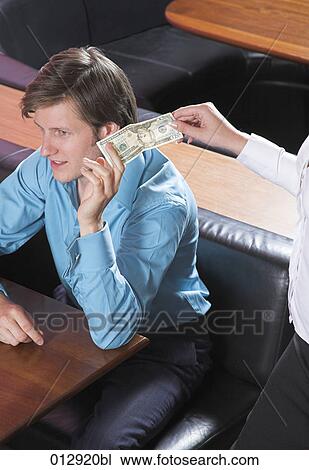 Stock Image - young man paying in restaurant. Fotosearch