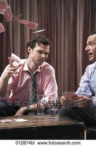 Stock Image - young man throwing playing cards in the air out of frustration. Fotosearch