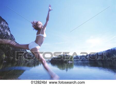 young woman jumping for joy in front of lake View Large Photo Image Stock Image - young woman jumping for joy in front of lake. Fotosearch
