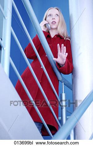 blond woman in red coat talking on mobile phone View Large Photo Image Stock Image - blond woman in red coat talking on mobile phone. Fotosearch