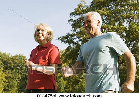 Stock Image - close-up of mature couple running through park. Fotosearch