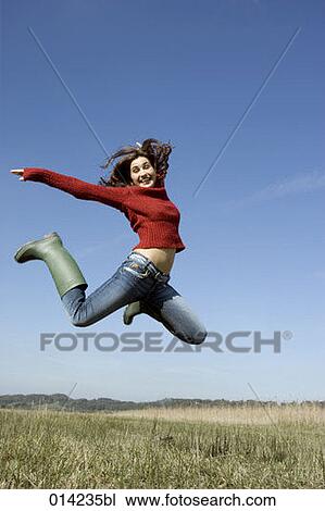happy young woman doing a jump in autumnal field View Large Photo Image Stock Image - happy young woman doing a jump in autumnal field. Fotosearch