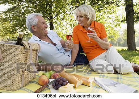 Stock Image - harmonious mature couple having picnic together. Fotosearch