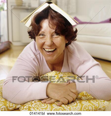 laughing mature woman with book on head View Large Photo Image Stock Image - laughing mature woman with book on head. Fotosearch