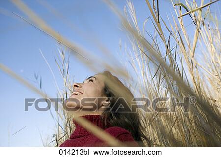 Stock Image - laughing woman in autumnal field. Fotosearch