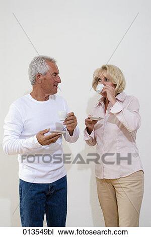 Stock Image - mature couple drinking espresso together. Fotosearch