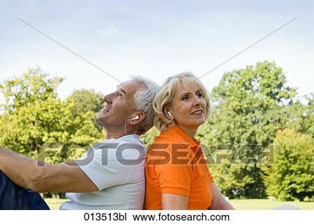 Stock Image - mature couple listening to music outdoors. Fotosearch