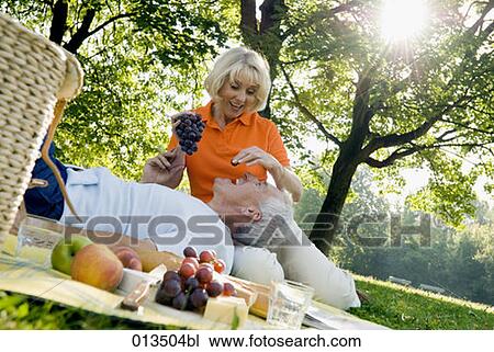 mature couple playing with grapes during picnic View Large Photo Image Stock Image - mature couple playing with grapes during picnic. Fotosearch