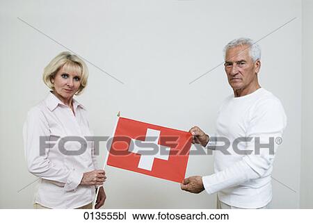 mature man and mature woman holding Swiss flag View Large Photo Image Stock Image - mature man and mature woman holding Swiss flag. Fotosearch