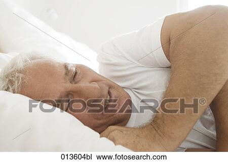 Stock Image - mature man sleeping in bed. Fotosearch