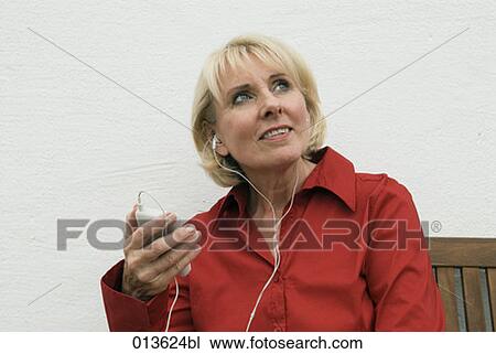 mature woman holding ipod listening to music View Large Photo Image Stock Image - mature woman holding ipod listening to music. Fotosearch