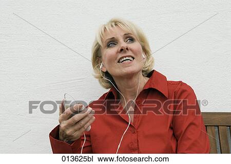 Stock Image - mature woman listening to music. Fotosearch