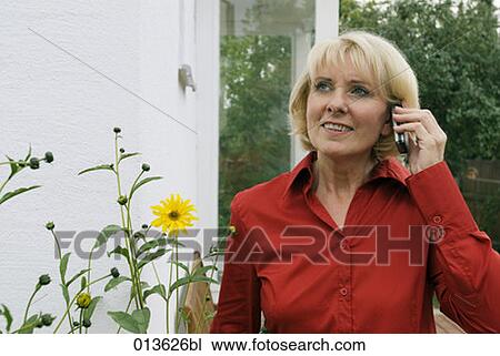 mature woman on terrace listening to mobile phone View Large Photo Image Stock Image - mature woman on terrace listening to mobile phone. Fotosearch