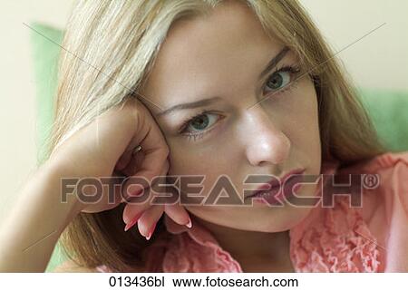 Stock Image - portrait of grumpy looking young woman. Fotosearch