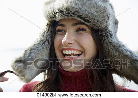 Stock Image - portrait of joyous young woman with fur hat. Fotosearch