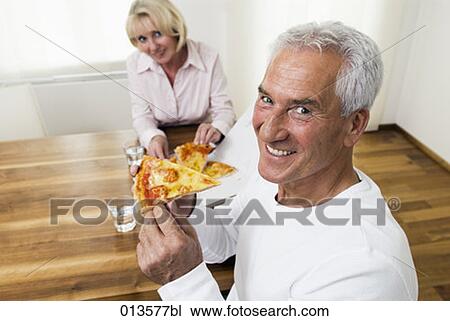 Stock Image - portrait of mature man eating pizza. Fotosearch