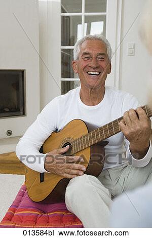 Stock Image - portrait of mature man playing guitar. Fotosearch