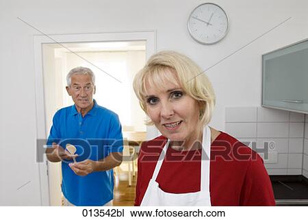 portrait of mature woman with husband looking annoyed at wooden spoon View Large Photo Image Stock Image - portrait of mature woman with husband looking annoyed at wooden spoon. Fotosearch