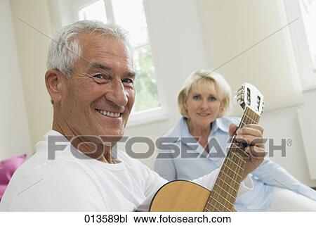 Stock Image - portrait of smiling man with guitar. Fotosearch