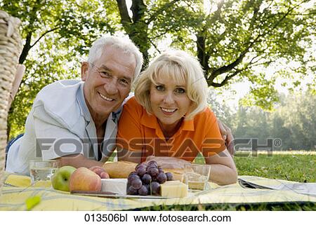 Stock Image - portrait of smiling mature couple at picnic. Fotosearch
