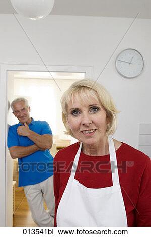 Stock Image - portrait of woman while man is giving a mischievous look. Fotosearch