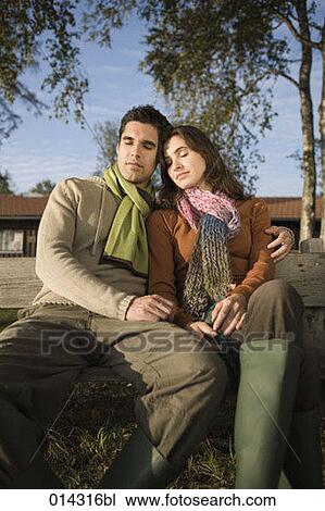 portrait of young couple sitting on bench with eyes closed View Large Photo Image Stock Image - portrait of young couple sitting on bench with eyes closed. Fotosearch
