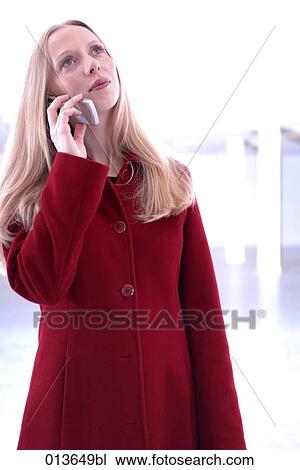 Stock Image - portrait of young woman listening attentively to her cellular phone. Fotosearch