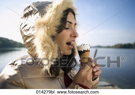 Stock Image - profile of young woman biting into ice. Fotosearch